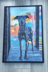 Painting of a dog framed by world under glass