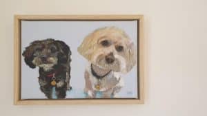 Two small dogs artwork framed by world under glass